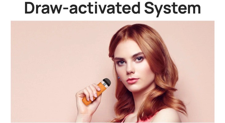 A young woman with red hair holding an orange Aspire Minican 4 vape kit
