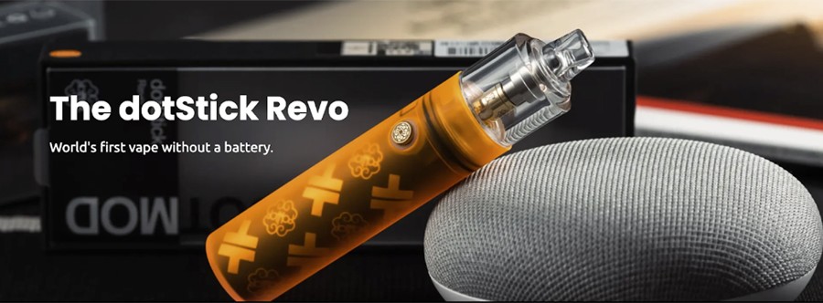An orange Dotmod Dotstick Revo vape kit is shown rested against a microphone head with its packaging in the background.